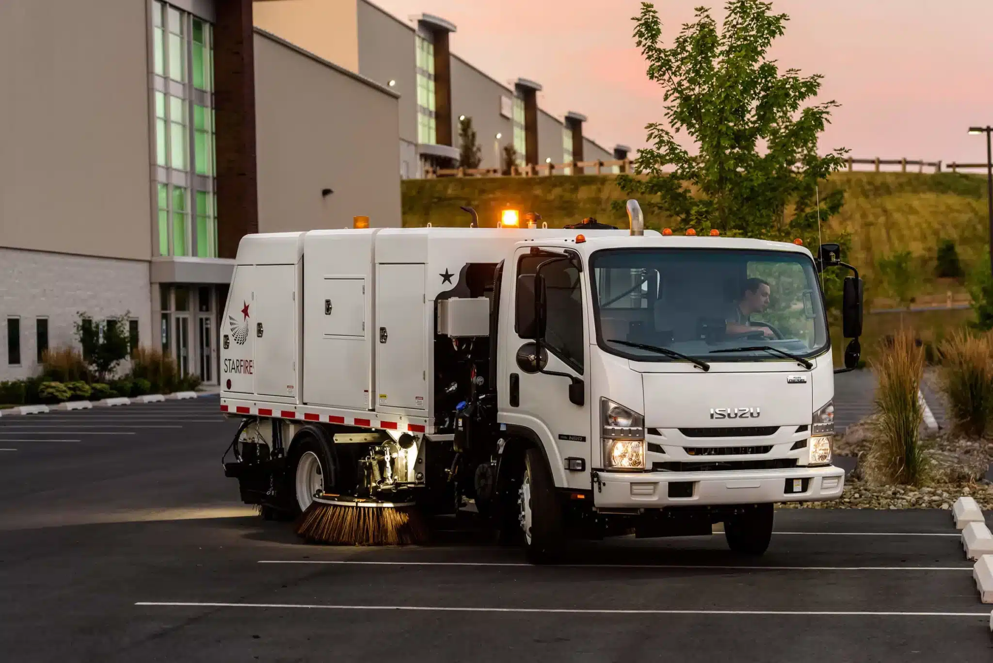 Isuzu NRR truck parked in a building's parking lot