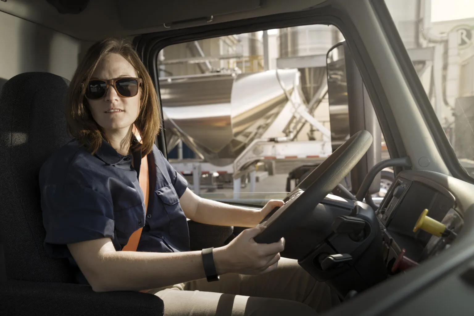 Female with sunglasses behind the wheel of a Volvo truck