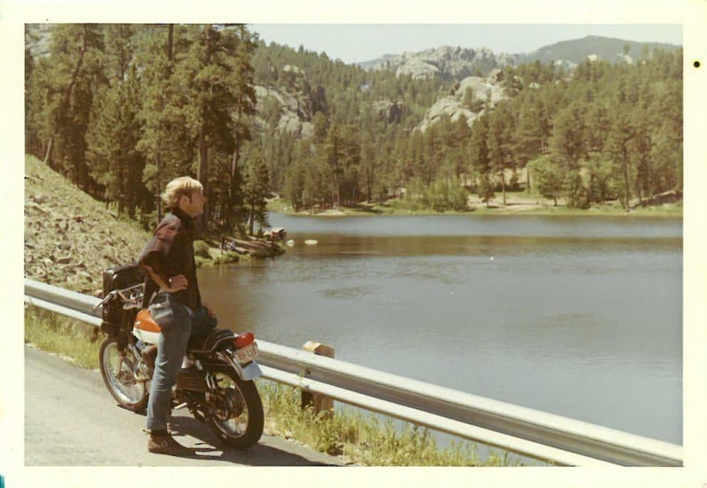 David A. Thompson as a young man on a motorcycle looking at a lake