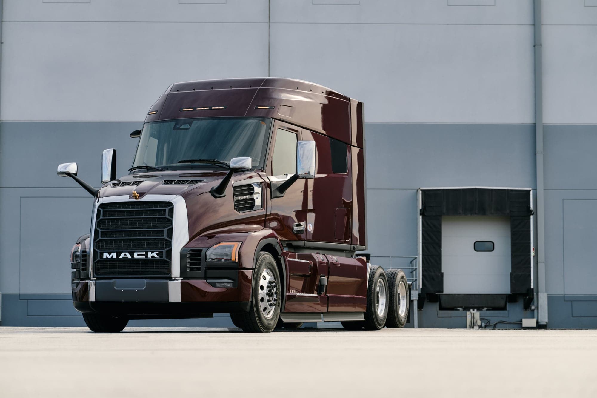 Red Mack Anthem parked outside a shipping building