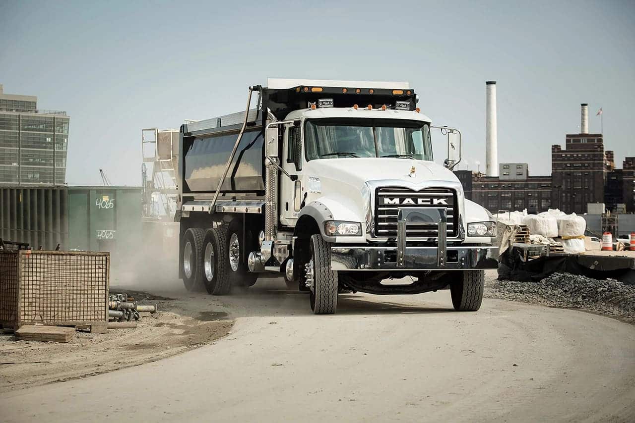 White Mack Granite dump truck driving in an active job site