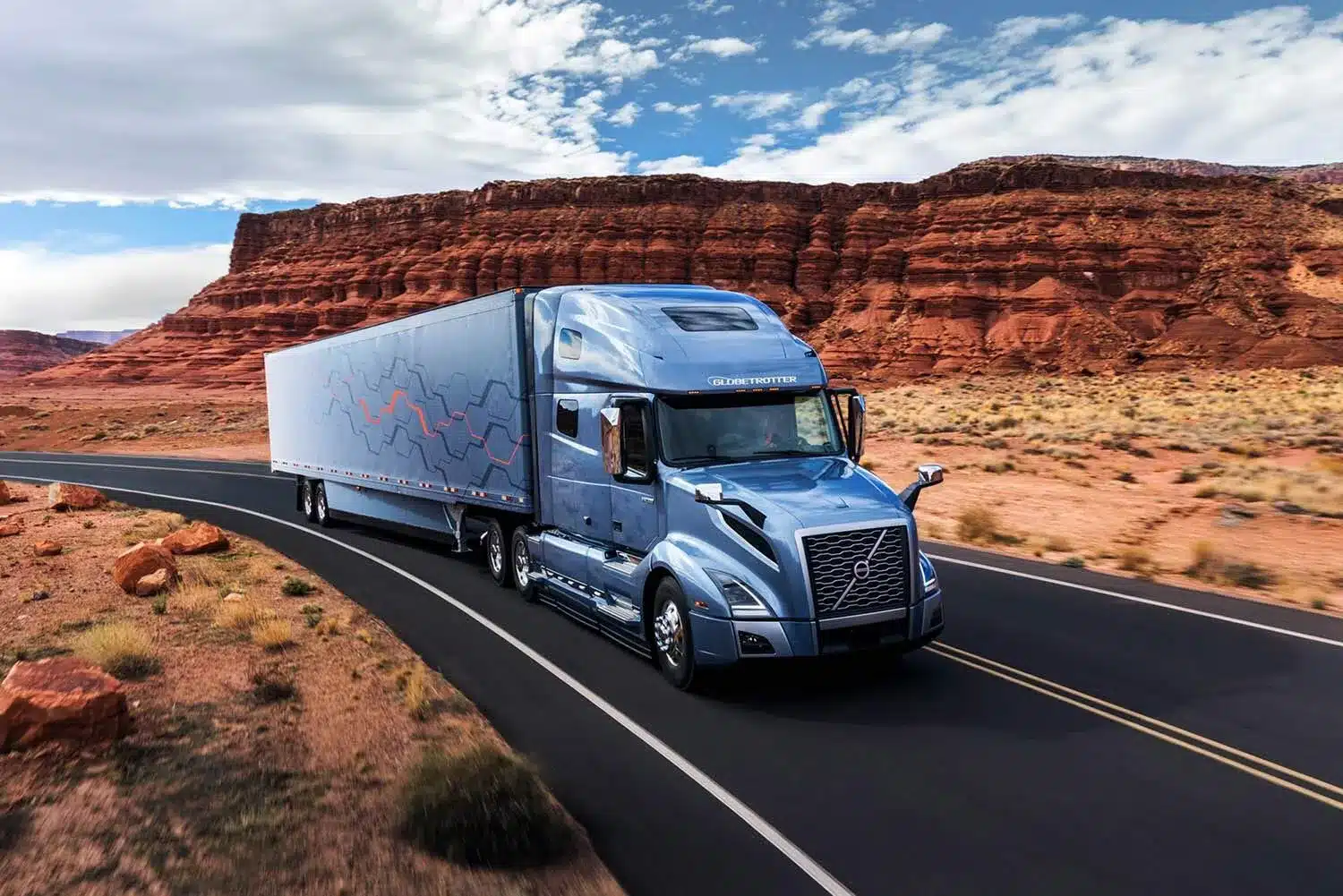 Blue Volvo VNL 860 driving through the grand canyon desert