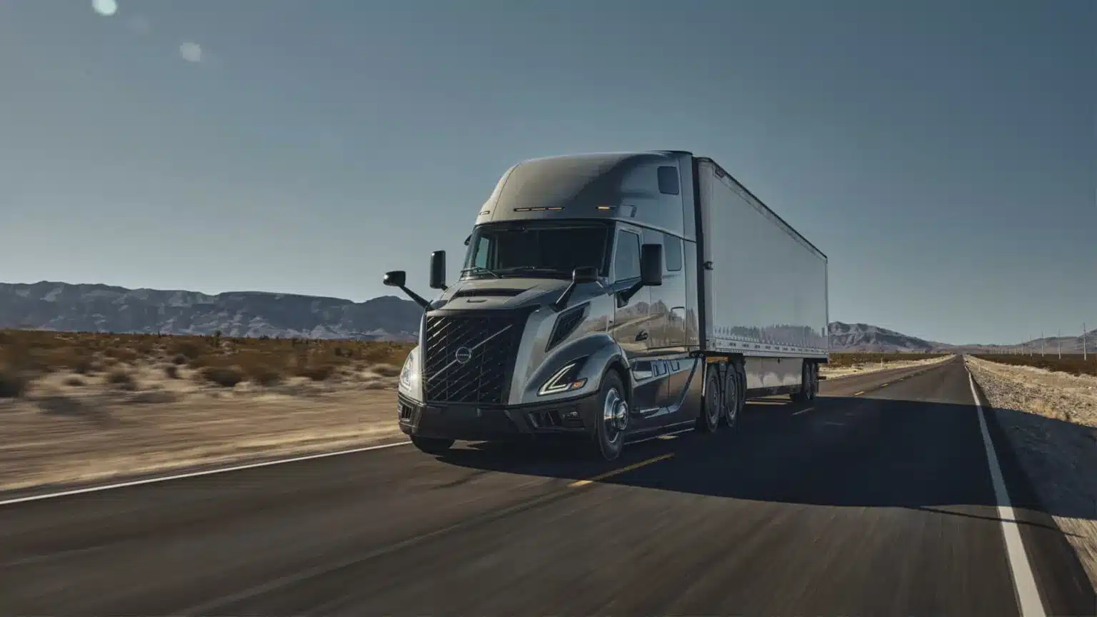 Grey all-new Volvo VNL 660 with a dry van driving in the desert