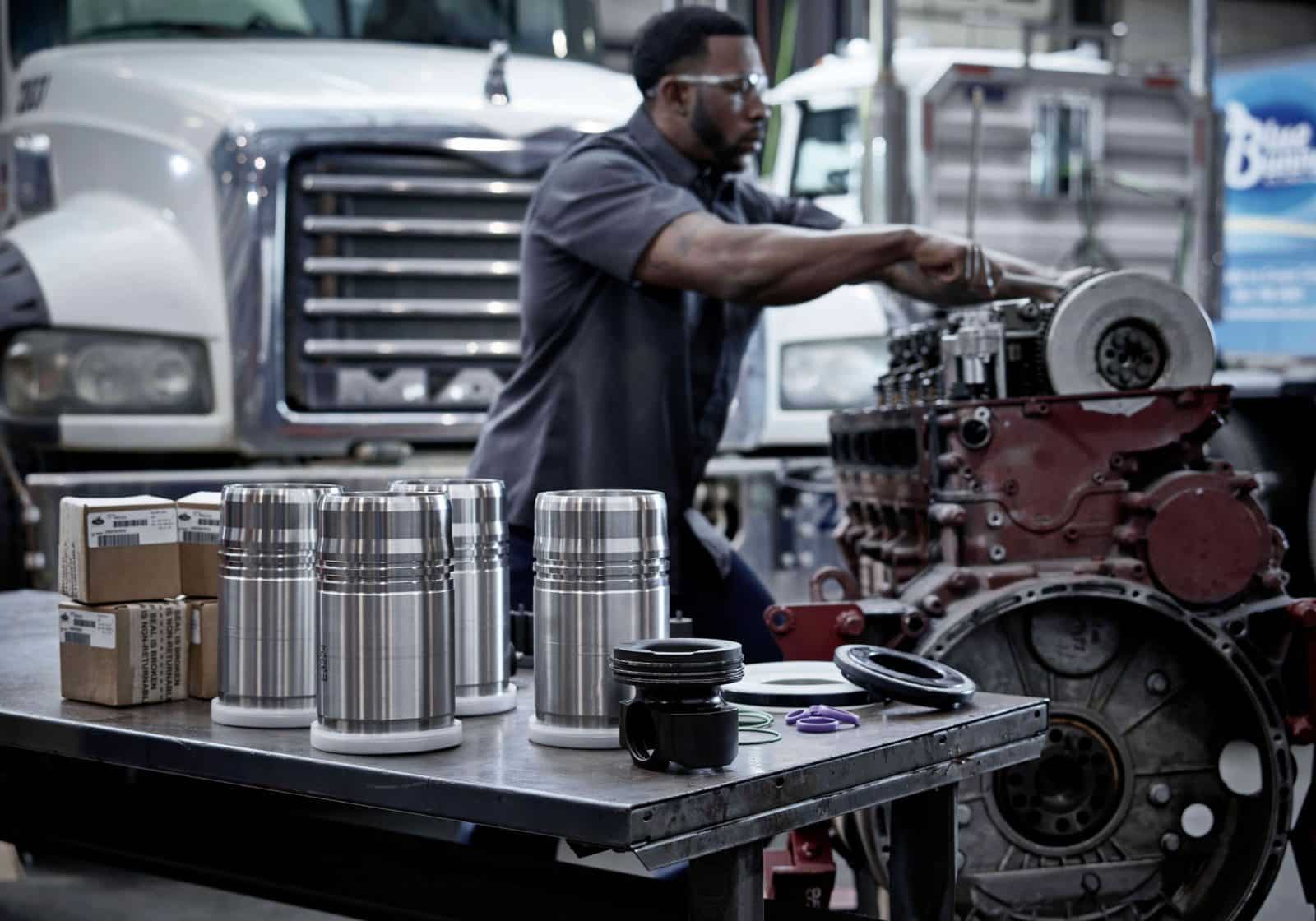 Mechanic working in a service department with parts in front of them