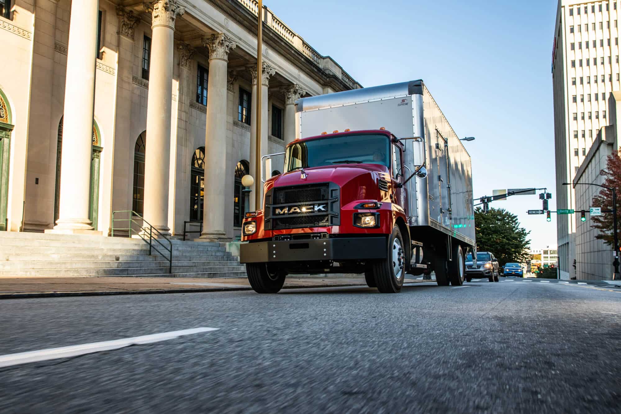 Red Mack MD driving down a street