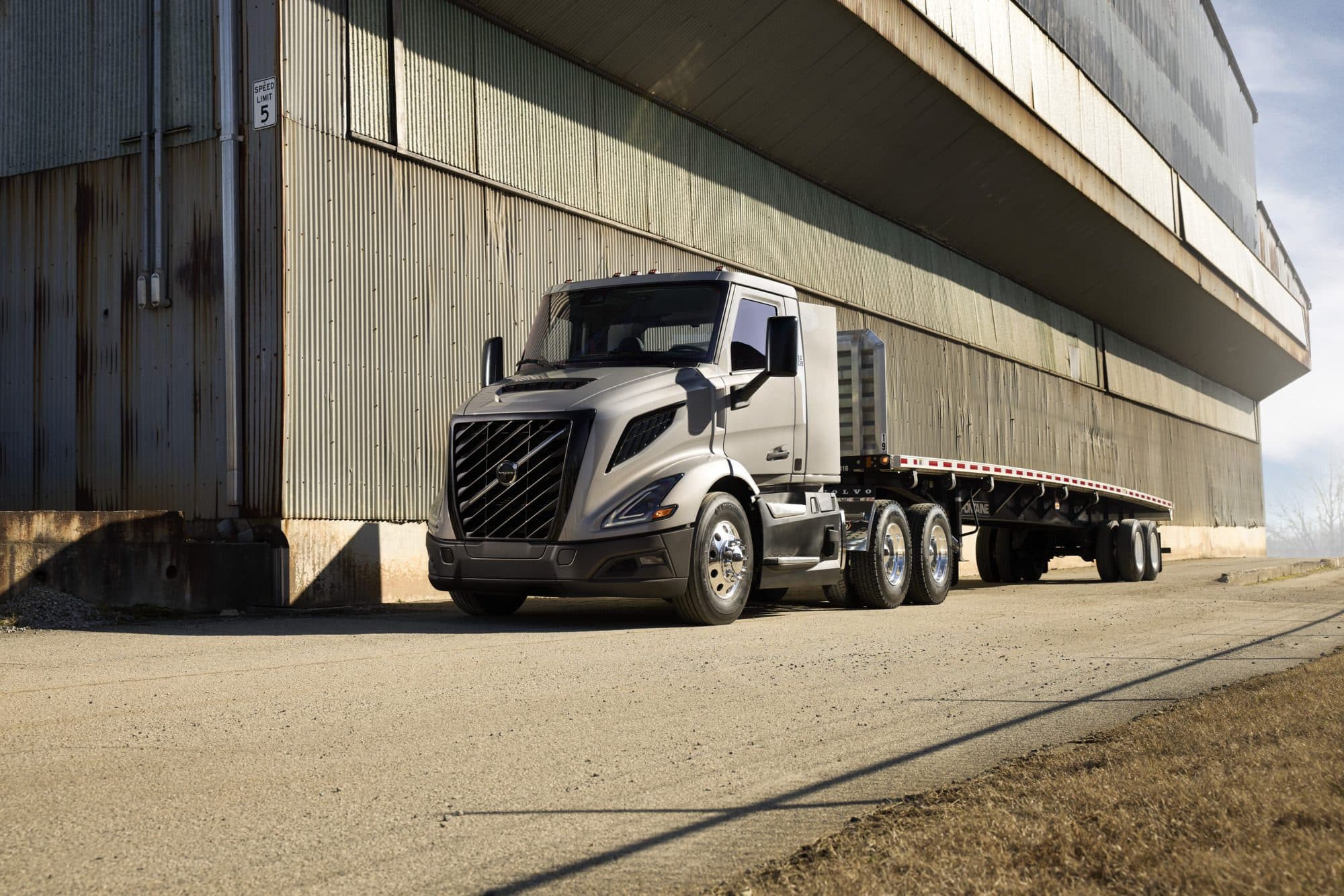 Grey all-new Volvo VNR 300 parked next to a large building
