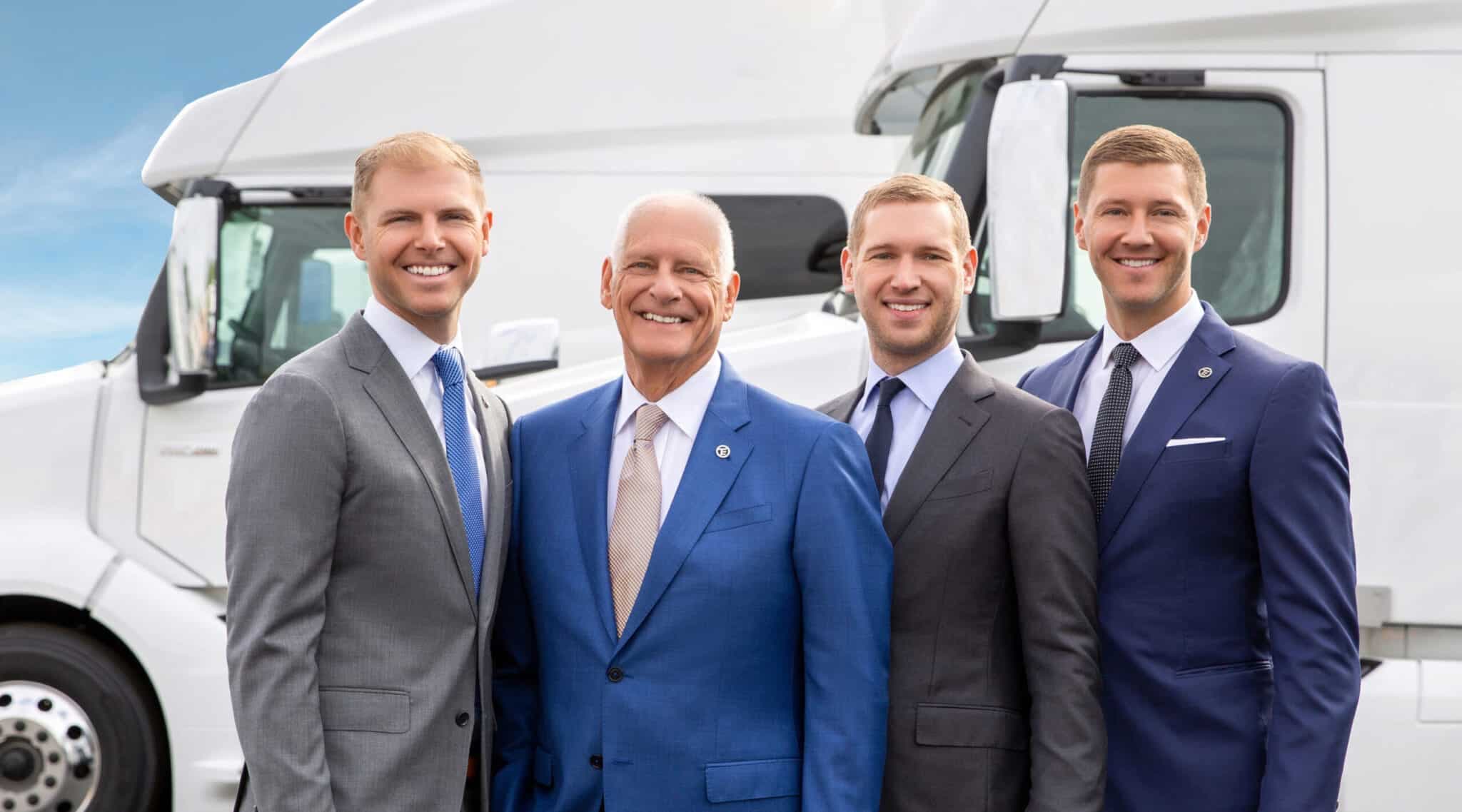 William Thompson, David A. Thompson, David O. Thompson and Chris Thompson, the owners of TEC Equipment standing in front of a white semi trucks.