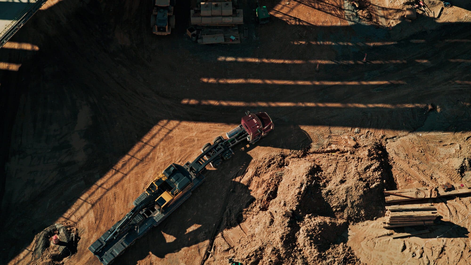 Ariel view of a Mack Keystone pulling heavy-duty construction equipment in a jobsite